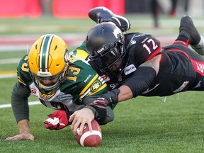 CALGARY;  NOVEMBER 22, 2014  --  Calgary Stampeders Juwan Simpson, right, and Edmonton Eskimos quarterback Mike Reilly lunge for the ball during the West Final at McMahon Stadium in Calgary. (Leah Hennel/Calgary Herald)   For Sports story by ?