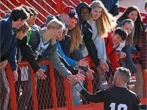 Calgary Stampeders quarterback Bo Levi Mitchell loves meeting with fans, such as these students from Madeleine d'Houet school, who high-fived him during an October practice. The pivot plans to have fun with fans this week at the Grey Cup.