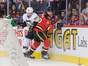 Michael Frolik of the Calgary Flames battles for the puck against Kris Letang of the Pittsburgh Penguins during Saturday's game at the Scotiabank Saddledome.