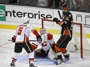 Anaheim Ducks' Ryan Getzlaf, right, celebrates Corey Perry's goal against Calgary Flames goalie Karri Ramo, centre, as Flames' Mark Giordano, left, watches during the third period on Tuesday, Nov. 24, 2015.