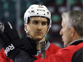 Calgary Flames centre Mikael Backlund listens to instruction from head coach Bob Hartley during practice on Monday.