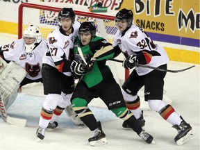 Reid Gardiner, seen sandwiched between Hitmen defencemen Ben Thomas (no longer with the team), left, and Travis Sanheim during a 2014 game, stunned Calgary with two late goals on Wednesday night.