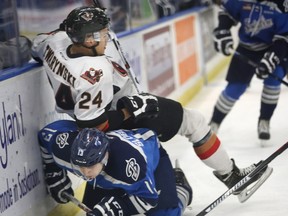 Saskatoon Blades Wyatt Sloboshan (underneath) and Calgary Hitmen's Carsen Twarynski collide on Tuesday night.