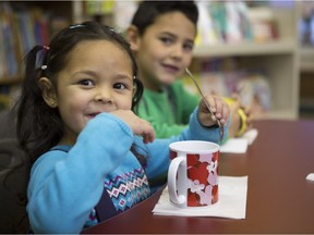 Lesly Jamie Gomez, kindergarten, left, and her brother Dante, grade one, finish off their breakfast at school thanks to the Food and Nutrition at School program (FANS) at St. Henry Elementary in Calgary, on November 19, 2015. Crystal Schick/Calgary Herald