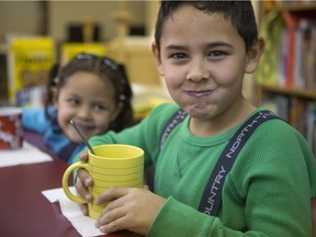Grade 1 student Dante Jamie Gomez smiles with his milk moustache while his sister, Lesly, giggles during breakfast at St. Henry Elementary  on Nov. 19, 2015. The Boys and Girls Club has been running its Food and Nutrition at School program for 28 years.