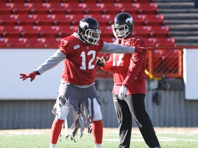 Juwan Simpson, left, shares a laugh with teammate Derek Wiggan during practice on Thursday. The chatty middle linebacker will be back on the field for Sunday's West Division semifinal against the B.C. Lions.