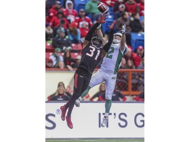Calgary Stampeders Brandon McDonald and Saskatchewan Roughriders Ryan Smith reach for the pass during game action at McMahon Stadium in Calgary, on October 31, 2015.