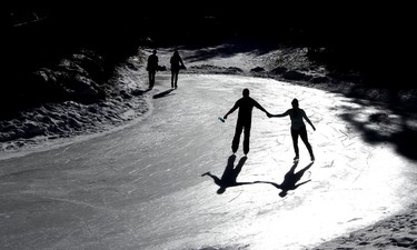 A beautiful balmy winter day has Dustin Gowenlock and Jaimie Hutchinson enjoying the river skating at Bowness Park, in Calgary on February 23, 2015. (Christina Ryan/Calgary Herald)