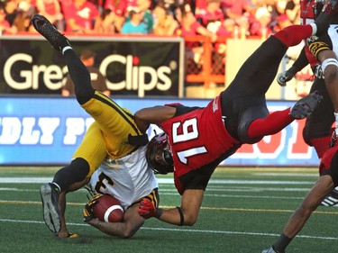 Calgary Stampeders Marquay McDaniel takes down the Hamilton Tiger-Cats Johnny Sears Jr. during their season opener at McMahon Stadium, on June 26, 2015. (Christina Ryan/Calgary Herald)