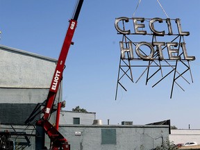 Crews take down the Cecil Hotel sign in Calgary on Aug. 14, 2015.