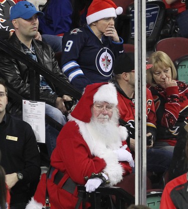 Santa watches the Calgary Flames take on Winnipeg Jets at the Scotiabank Saddledome in Calgary on December 22, 2015.