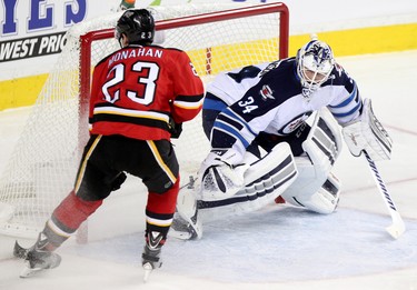 Calgary Flames Sean Monahan, left, , rtakes a shot on Winnipeg Jets goalie Michael Hutchinson during their game at the Scotiabank Saddledome in Calgary on December 22, 2015.