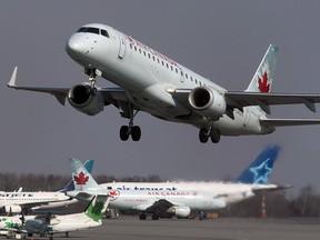 An Air Canada jet coming in for a landing as a WestJet plane gets ready to take off at the Edmonton International Airport, January 15, 2013.