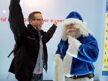 Toronto's Tom Knezic reacted after WestJet's Blue Santa awarded his family with a free trip anywhere WestJet flies during a visit to the CN Tower on Dec. 9, 2015 during the 12,000 Mini Miracle day.