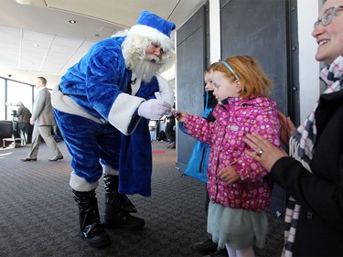 WestJet's Blue Santa gave three-year-old Moira Knezic a tree ornament while he made a trip up the CN Tower on Dec. 9, 2015 during the 12,000 Mini Miracle day.