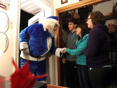 WestJet's Blue Santa got a welcome from members of the Gould Family, from left, Taryn Gould, Rene Gould and Erin Gould in Truro, NS on Dec. 9, 2015 as he delivered a wish of an all expenses trip to Walt Disney World in Orlando for 10 days.