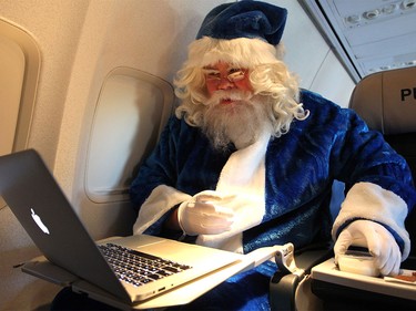 WestJet's Blue Santa sat back to enjoy some milk and cookies while watching some Christmas movies during his Toronto bound flight from Halifax on Dec. 9, 2015 during the 12,000 Mini Miracle day.