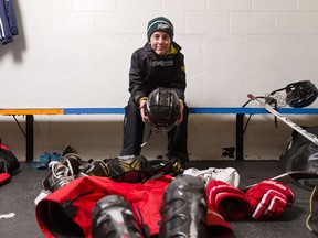 Liam Lucas, centre, shows off the hockey gear he uses while playing for the Trailwest Peewee 4 Wolves at the Stu Peppard Arena in Calgary on Monday, Dec. 14, 2015.