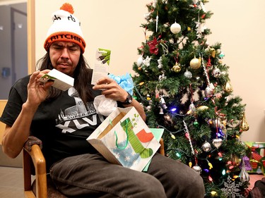 Richard Ritchie opens gifts at the Calgary Drop-In and Rehab Centre on Dec. 25, 2015.