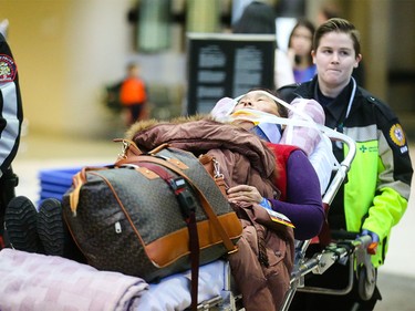 Patients are transported to hospital from the Calgary International Airport in Calgary on Wednesday, Dec. 30, 2015.