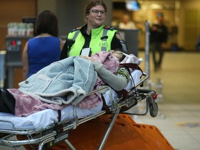 Patients are transported to hospital from the Calgary International Airport in Calgary on Wednesday, Dec. 30, 2015.