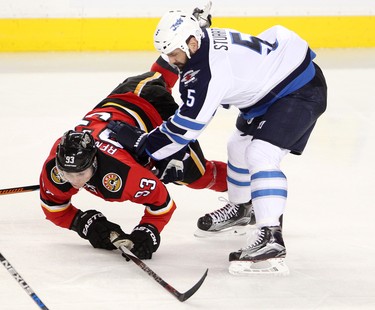 Calgary Flames Sam Bennett, left, collides with Winnipeg Jets Mark Stuart during their game at the Scotiabank Saddledome in Calgary on December 22, 2015.