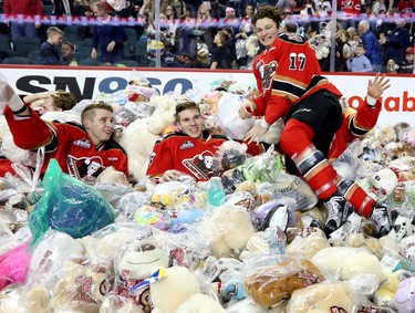 Calgary Hitmen Jordy Stallard, right, jumps into a pile of bears after scoring on the Swift Current Broncos during the annal Teddy Bear Toss at the Scotiabank Saddledome.