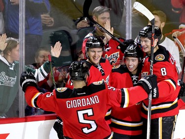 Calgary Flames Johnny Gaudreau, middle, celebrates his third goal of the game against the Winnipeg Jets, with teammates at the Scotiabank Saddledome in Calgary on December 22, 2015.