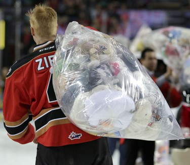 Calgary Hitmen Micheal Zipp helps clean up the ice during the annual Teddy Bear Toss at the Scotiabank Saddledome on December 6, 2015.