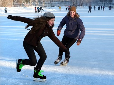 Jill Horne chases her cousin Priska as they enjoy a chilly white Christmas Day as they head to Bowness Park lagoon for skating, in Calgary on December 25, 2015.