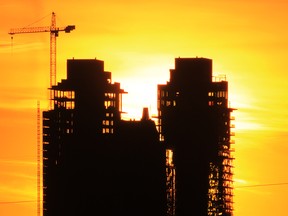 The setting sun silhouettes Victoria Park condo towers under construction in Calgary