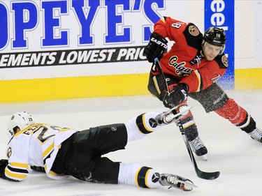 The Calgary Flames' Matt Stajan moves around the Boston Bruins' Landon Ferraro during third period NHL action at the Scotiabank Saddledome on Friday December 4, 2015.