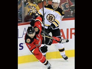 The Calgary Flames Mark Giordano and the Boston Bruins' Ryan Spooner collide during the first period of NHL action at the Scotiabank Saddledome on Friday December 4, 2015.