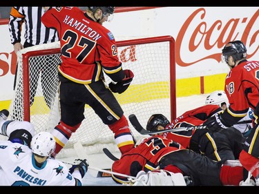 Calgary Flames and San Jose Sharks players pile up around Flames goaltender Karri Ramo who snagged a puck that narrowly missed going in during the second period of NHL action against the at the Scotiabank Saddledome on Tuesday December 8, 2015.