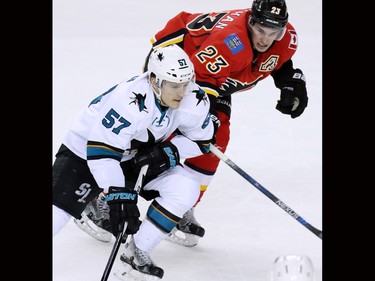 Calgary Flames' forward Sean Monahan and the San Jose Sharks' Tommy Wingels chase the puck during the third period of NHL action at the Scotiabank Saddledome on Tuesday December 8, 2015.