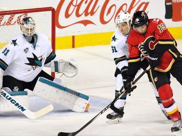 CALGARY, AB: DECEMBER 08, 2015 - The Calgary Flames' David Jones and San Jose Sharks Justin Braun wrestle in front of Sharks'  goaltender Martin Jones during the first period of NHL action at the Scotiabank Saddledome on Tuesday December 8, 2015.