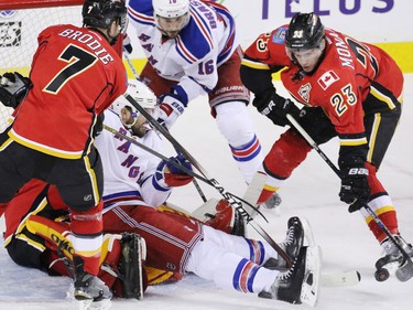 Calgary Flames and New York Rangers players scramble for a loose puck in front of Flames goaltender Jonas Hiller during first period NHL action in Calgary on Saturday December 12, 2015.