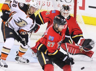 The Anaheim Ducks' Carl Hagelin and the Calgary Flames Dougie Hamilton look to control the puck in front of Flames goalie Karri Ramo during NHL action at the Scotiabank Saddledome on Tuesday November 29, 2015.