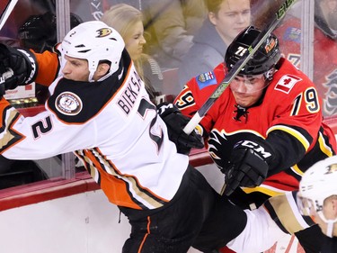 The Anaheim Ducks' Kevin Bieksa is checked by the Calgary Flames' Micheal Ferland during NHL action at the Scotiabank Saddledome on Tuesday November 29, 2015.