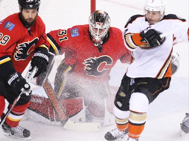 The Anaheim Ducks' Andrew Cofliano and the Calgary Flames' Derek Engelland slide in front of Calgary Flames' goaltender Karri Ramo during NHL action at the Scotiabank Saddledome on Tuesday November 29, 2015.