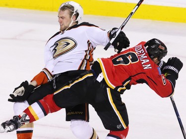 The Anaheim Ducks' Sami Vatanen is checked by the Calgary Flames' Dennis Wideman during NHL action at the Scotiabank Saddledome on Tuesday November 29, 2015.