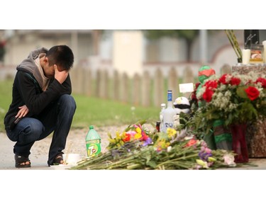 Kenny Nguyen step brother of murder victim David Quatch collects his thought in front of the memorial growing in front of the California Boulevard home where he was killed on the weekend. Said Raed Abdulbaki, 20, of Calgary, was charged Wednesday with second-degree murder in his death.