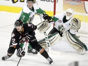 Mark Kastelic of the Calgary Hitmen sets up in goalmouth of Prince Albert Raiders netminder Rylan Parenteau and defender Jesse Lees in the third period of their game at the Scotiabank Saddledome on Thursday night.