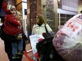 Syrian refugees Salem and Rita Kallas and their son Elie, 4, bundle up after arriving at the Calgary International Airport on Dec. 11, 2015.