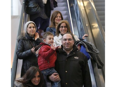 Syrian refugees Salem and Rita Kallas, right, and their son Elie, 4, arriving at the Calgary International Airport on December 11, 2015.
