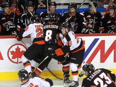 Tigers Caleb Fantillo, 23,  and Cole Sanford, 26, take Hitmen Loch Morrison out of the play as the Calgary Hitmen hosted the Medicine Hat Tigers in Western Hockey League action at the Saddledome on Saturday, December 19, 2015.
