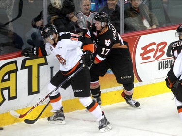 Tigers Ty Schultz tries to keep the puck away from Hitmen Jordy Stallard as the Calgary Hitmen hosted the Medicine Hat Tigers in Western Hockey League action at the Saddledome on Saturday, December 19, 2015.