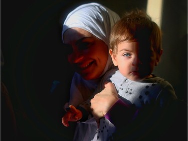 Nour, a Syrian refugee, and her 10 month old son Kareem enjoy their new home in Calgary with her four children.