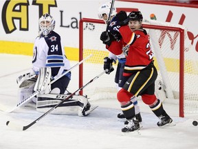 Jiri Hudler, right, celebrates Johnny Gaudreau's first of three goals on Winnipeg Jets goalie Michael Hutchinson Tuesday night at the Scotiabank Saddledome.