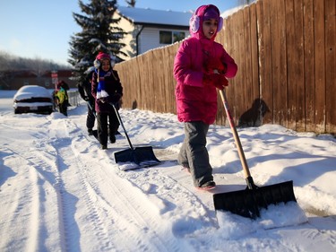 Amina Farooq, 8, right, along with other members of the Islamic Association of North West Calgary, help shovel sidewalks.